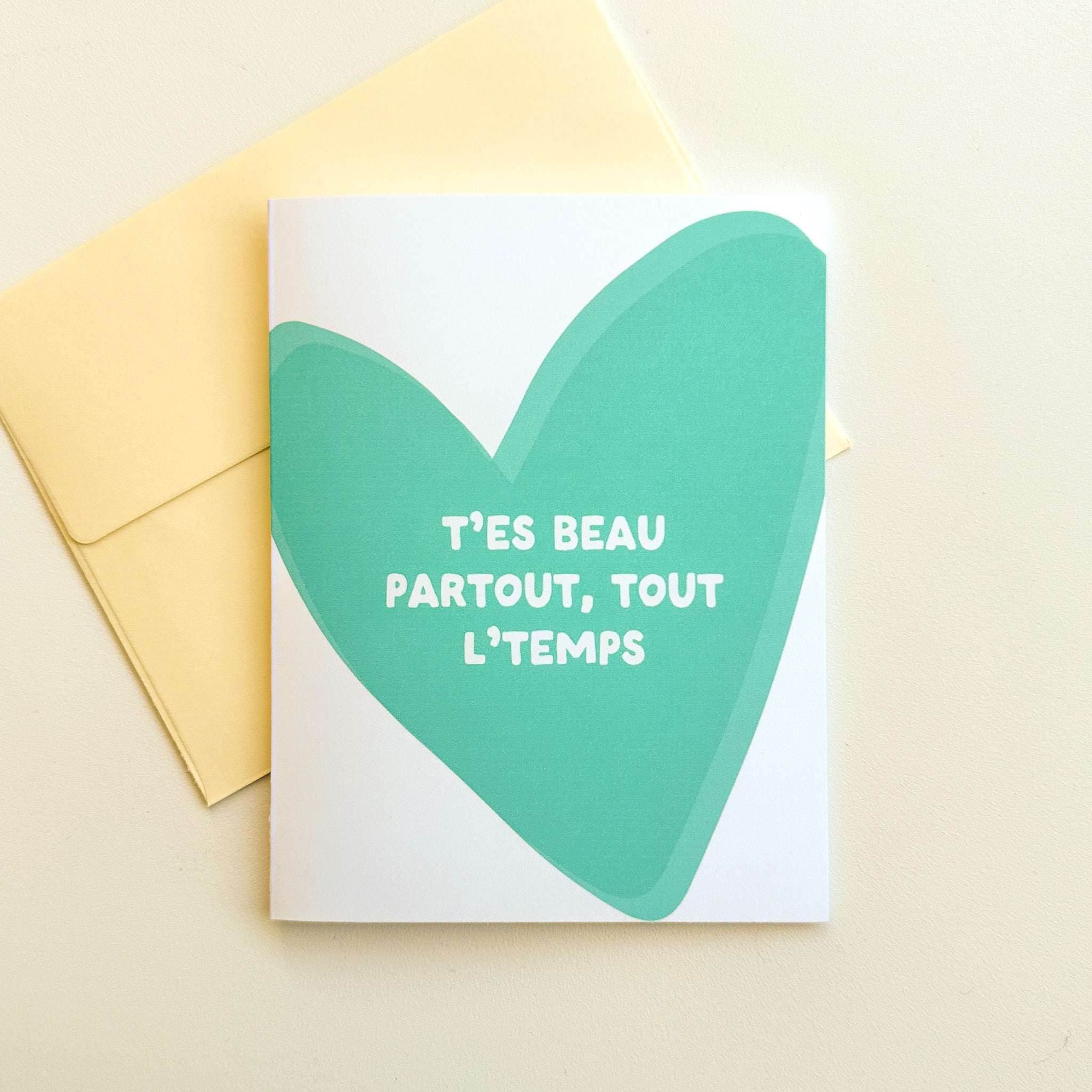 Illustration d'un cœur turquoise avec la phrase T'es beau partout, tout le temps en typographie moderne et épurée